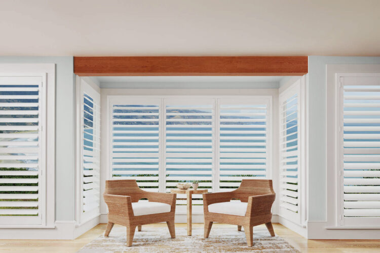 Wooden aesthetic living space with sliding doors revealing scenic beach and nature view, covered by Luxaflex Polysatin Shutters. For sale in Complete Blinds Brisbane showroom.