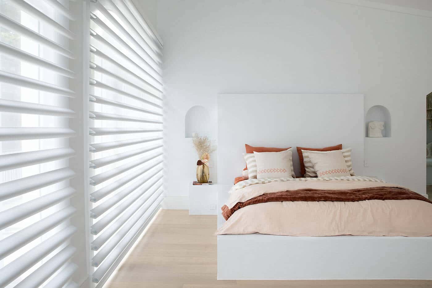 pirouette-shadings-benefit-03 Pirouette Shades with softly curved fabric vanes allowing flexible light control and UV protection diffusing light in a cozy bedroom. Innovative and minimalist design. For sale at Complete Blinds Australia.