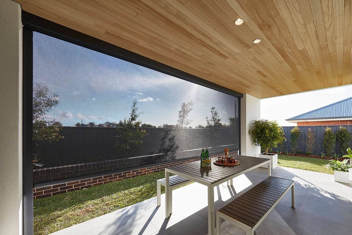 evo-awnings-benefit-07 Modern and elegant home patio with garden featuring Evo Outdoor Awning provinding shade covering for the patio. Made in Australia. Available at Complete Blinds Brisbane.