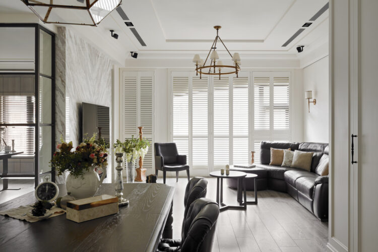 Modern contemporary living space with dark brown accents and classical design, featuring Woodlore Shutters. Made in Australia. Available at Complete Blinds Brisbane.