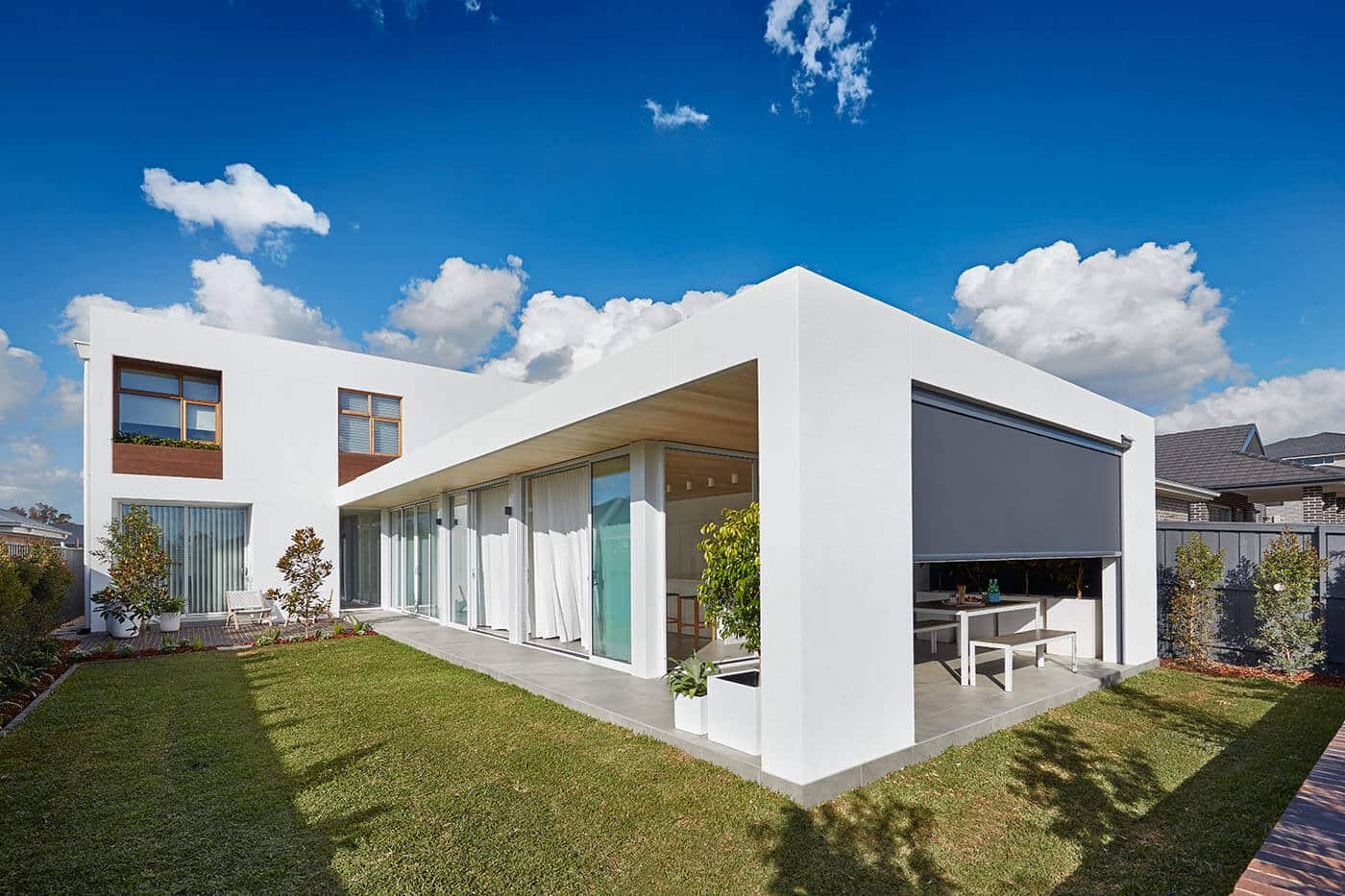 A modern and contemporary home with garden and patio installed with Evo Awnings by Complete Blinds Brisbane.