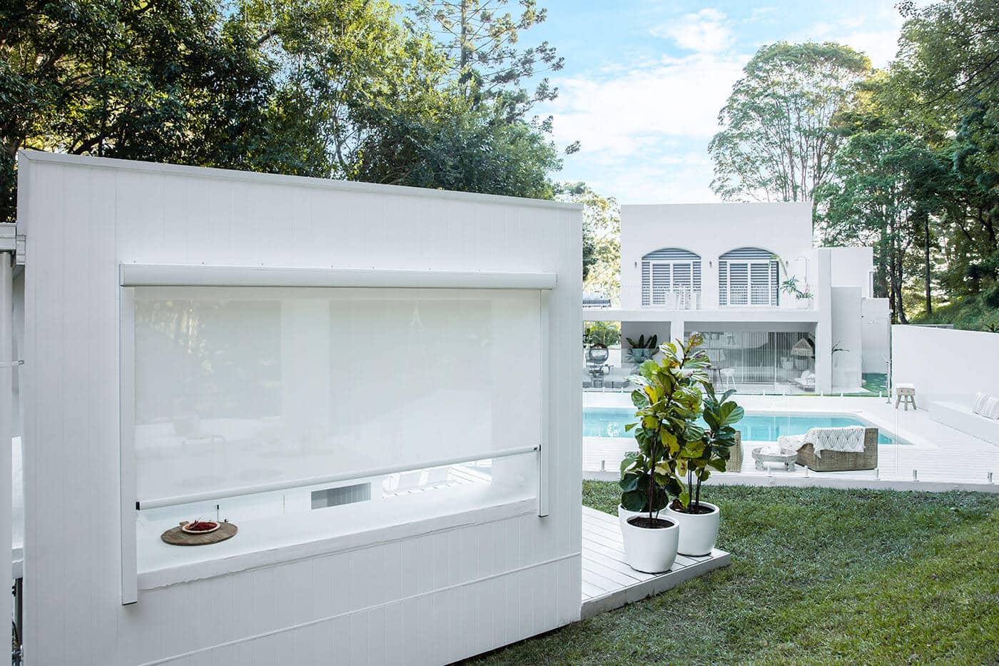 White classical themed home with swimming pool featuring outdoor Evo Awnings installed by Complete Blinds Australia.