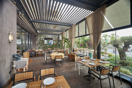 A fancy and contemporary restaurant featuring Retractable Louvre Roof Pergola Awnings by Complete Blinds Brisbane.
