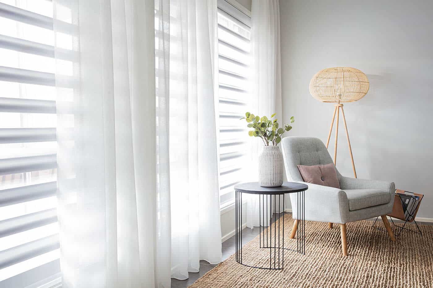 Aesthetic zen living room with ceiling-height windows installed with sheer white curtains gently filtering sunlight in to the room. Curtains for sale at Complete Blinds Cleveland.
