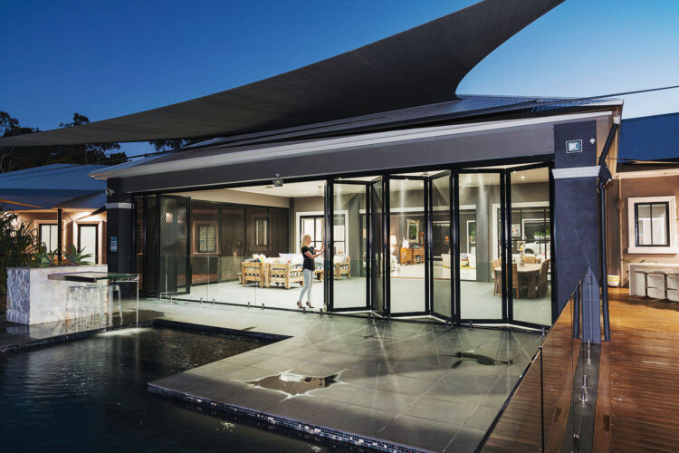 Modern and luxurious home with swimming pool, Crimsafe glass doors installed at patio. Available at Complete Blinds Brisbane.
