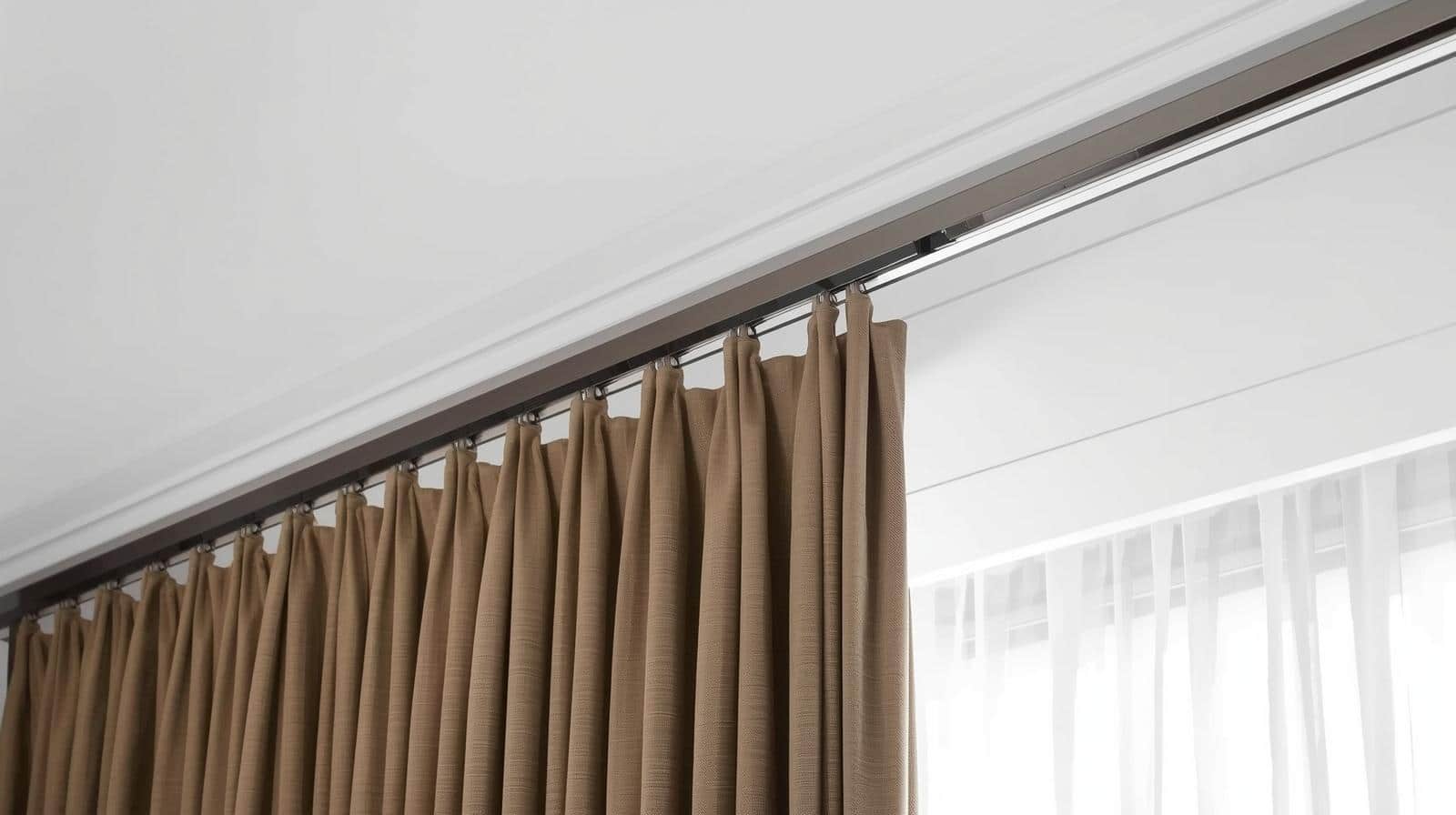 Ceiling‑mounted curtain track creating a floor‑to‑ceiling hotel look