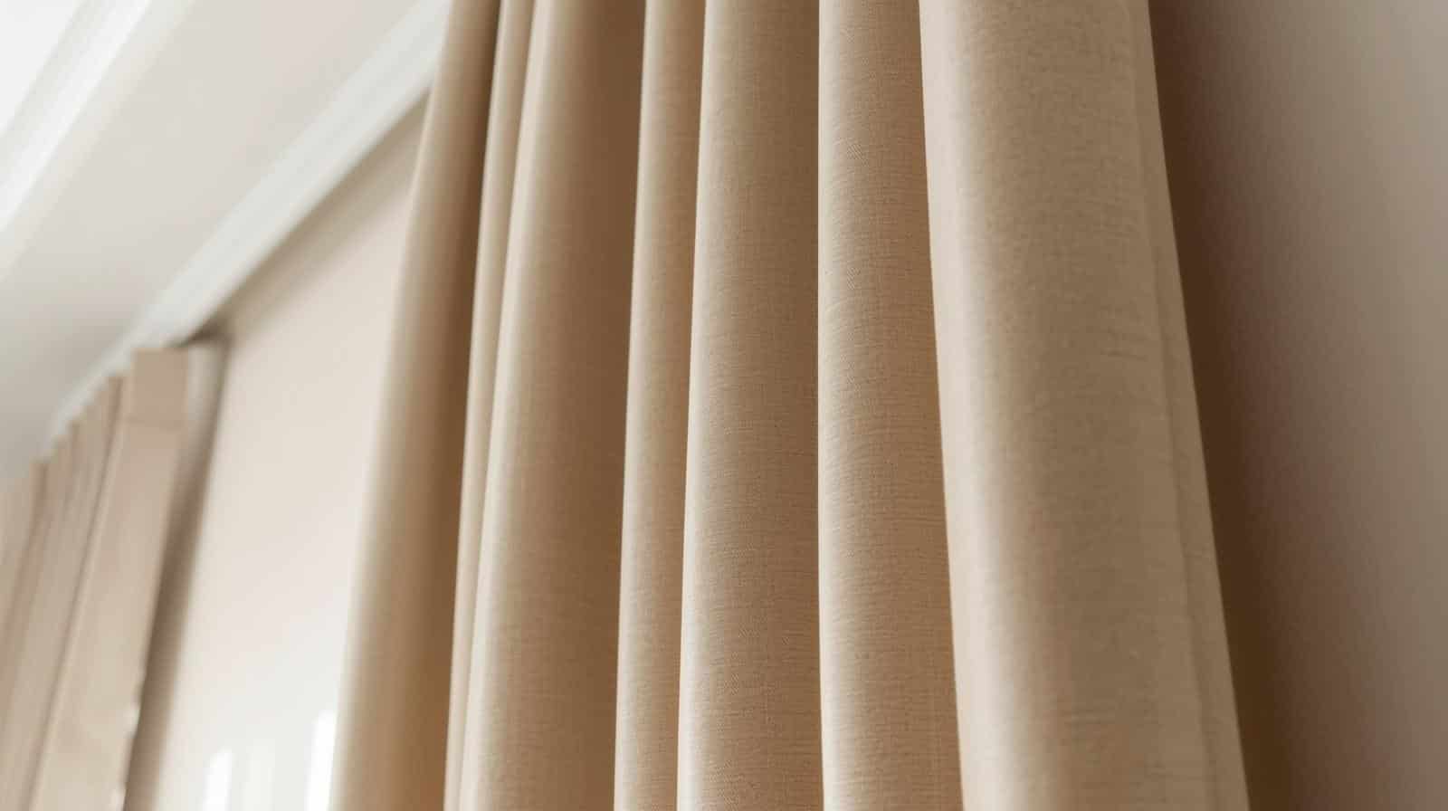 Ceiling-mounted blockout curtains with returns to wall eliminating light gaps